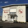 Exterior view of the Bernstein Motel with flowers and blue sky.