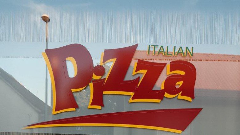 Window pane with large lettering 'Italian Pizza' in red and yellow.