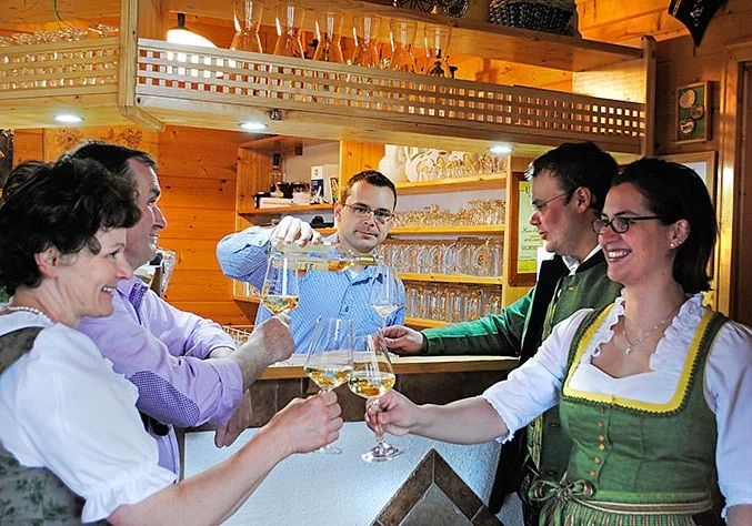 People clink glasses with drinks at a cozy bar.