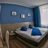 Modern guest room with blue accent, double bed and desk.