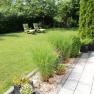 Garden with lawn, sun loungers and planted border.