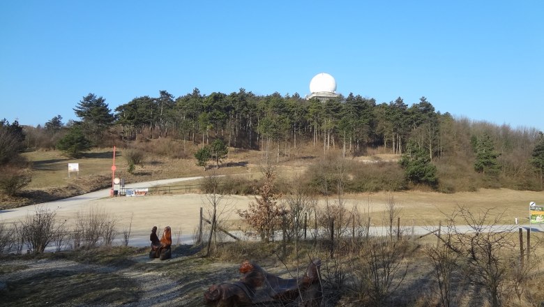 Landscape with hills, forest and radar dome under a blue sky.