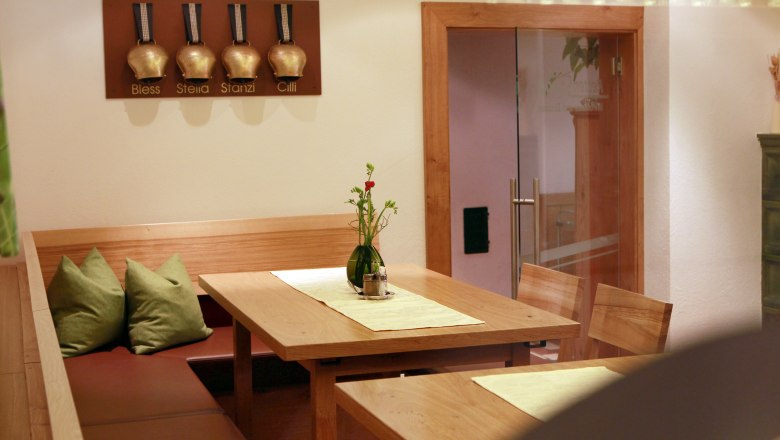 Cozy seating area in a restaurant with wooden table and green cushions.