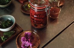 Ein liebevoll zubereitetes Glas mit aromatischem Nesselöl steht bereit, um die Sinne zu verzaubern. Umgeben von frischen Kräutern und bunten Blüten entfaltet sich hier die Kunst der Kulinarik inmitten der idyllischen Landschaft des Mostviertels. Ein Fest für die Augen und den Gaumen, das zum Entdecken und Genießen einlädt.