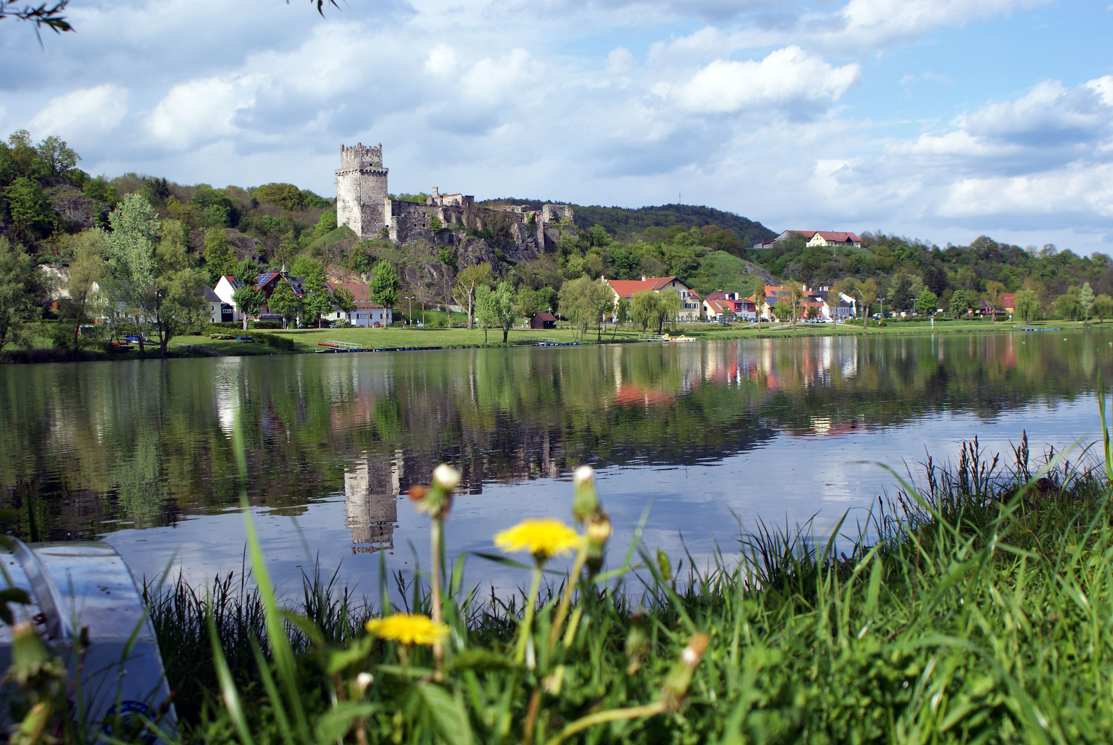 Weitenegg Castle and village on the riverbank with reflection in the water.