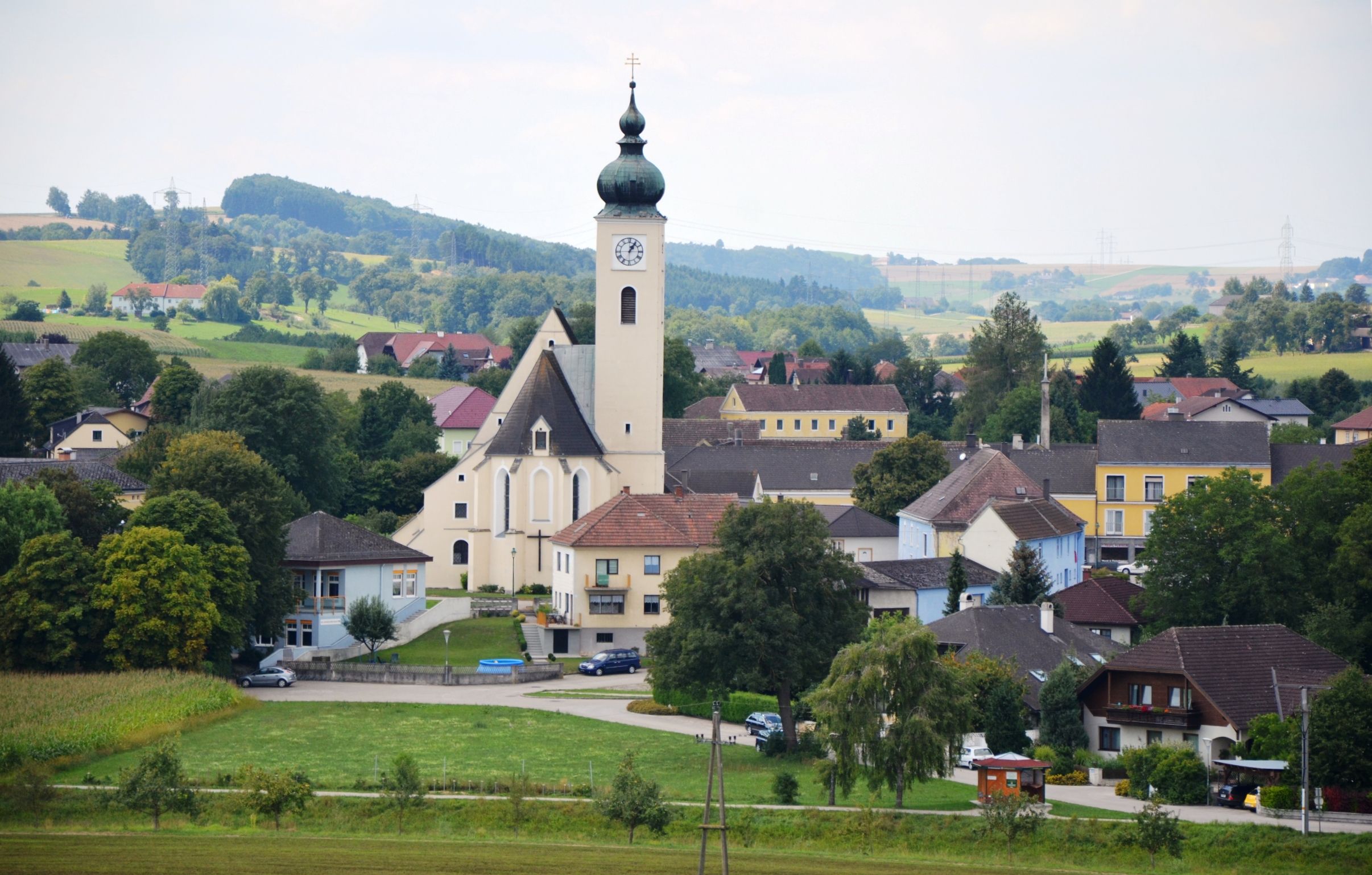 View of the market town of Ruprechtshofen with church and surrounding houses in a rural landscape.