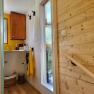 Interior view of a bathroom with wood paneling and yellow accents.