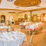 Elegant ballroom with laid tables and wooden furnishings.
