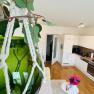 Modern kitchen in a vacation apartment with green glass vase in the foreground.
