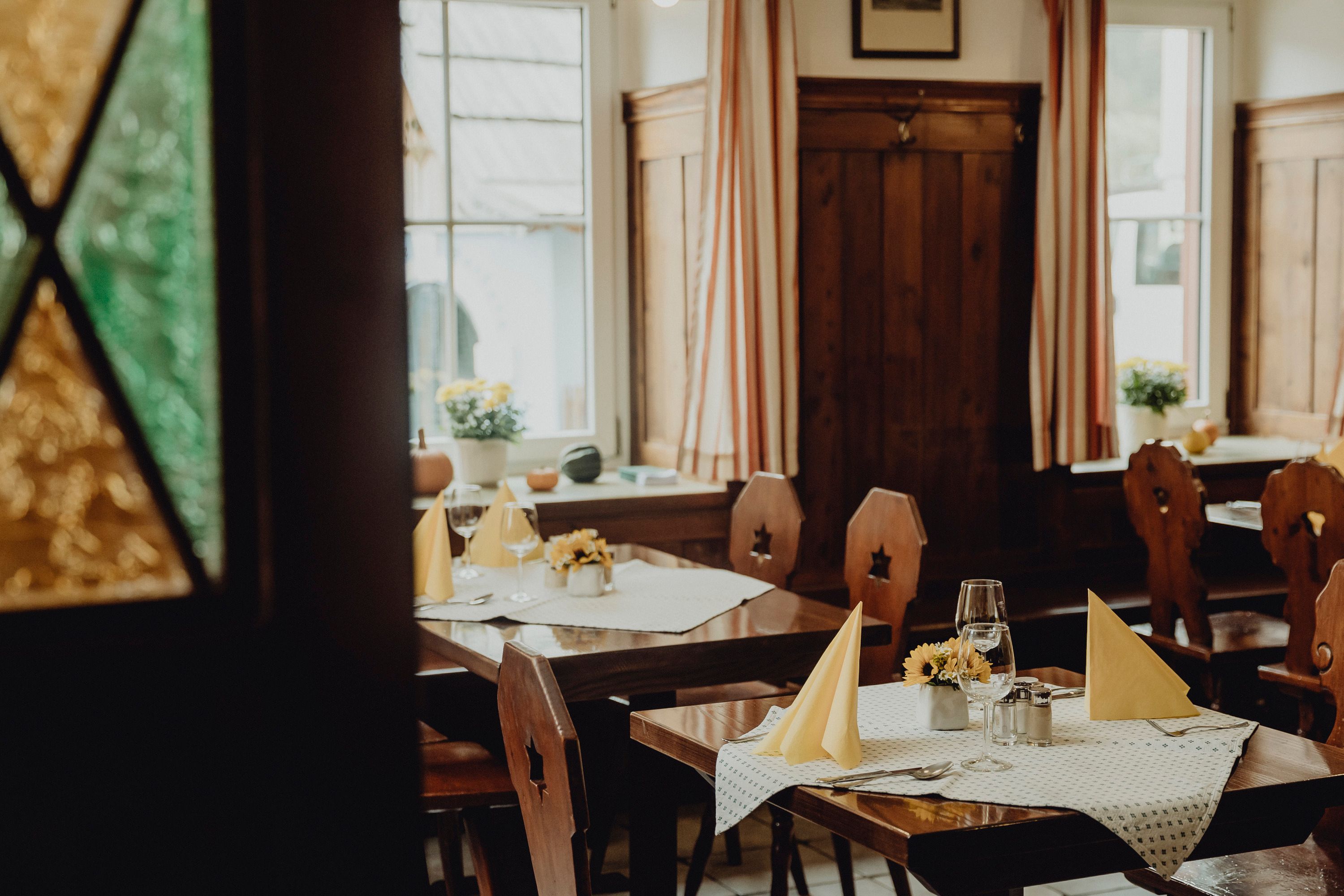 Cozy restaurant with wooden furniture and laid tables.