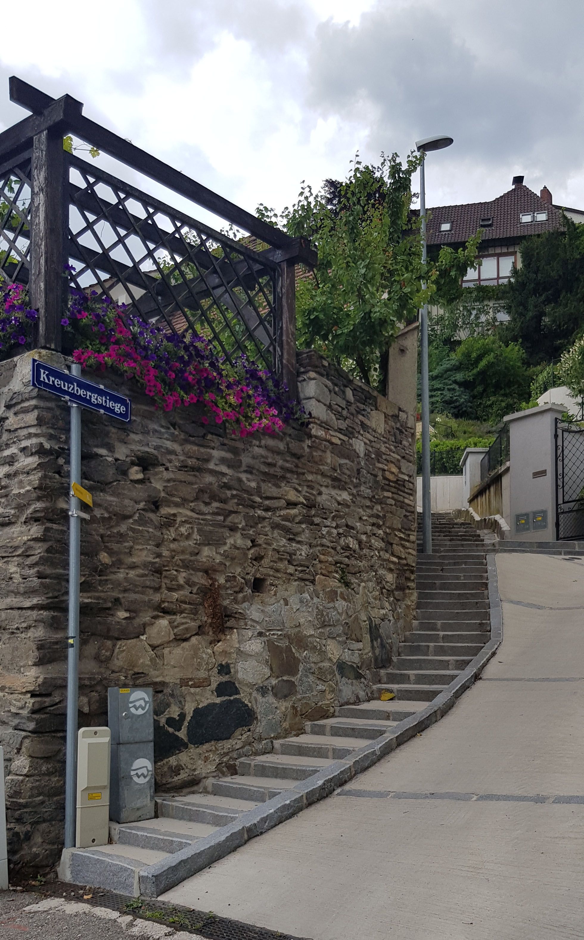 Stone staircase with flowers and street sign 'Kreuzbergstiege' in Krems.
