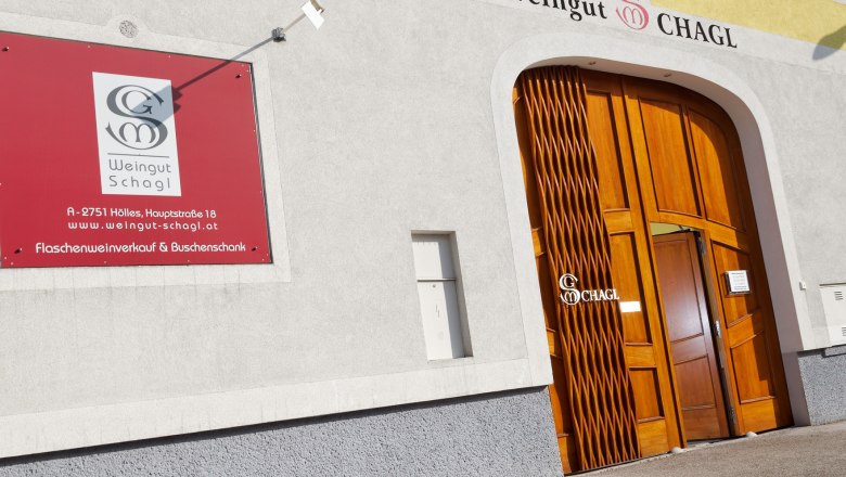 Entrance to the Schagl winery with yellow fa&ccedil;ade and wooden door.
