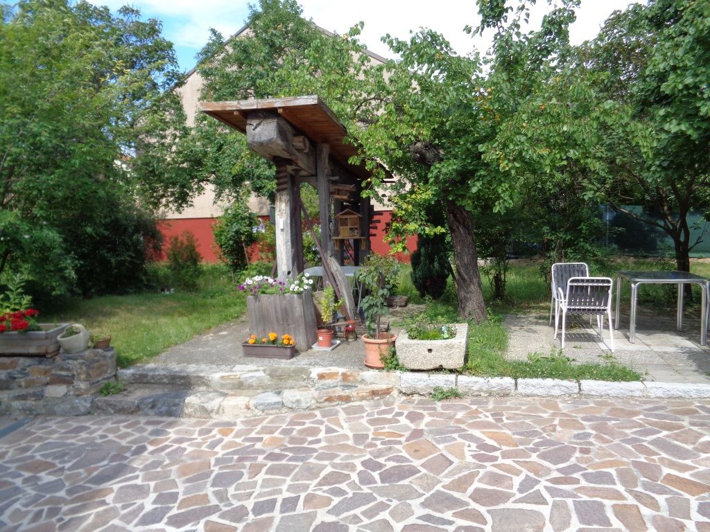 Garden with stone floor, plants and garden furniture.