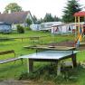 Campsite with table tennis table, playground and caravan.