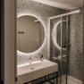 Modern bathroom with illuminated mirror and shower.