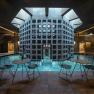 Interior view of a modern spa with pool, tables and chairs.