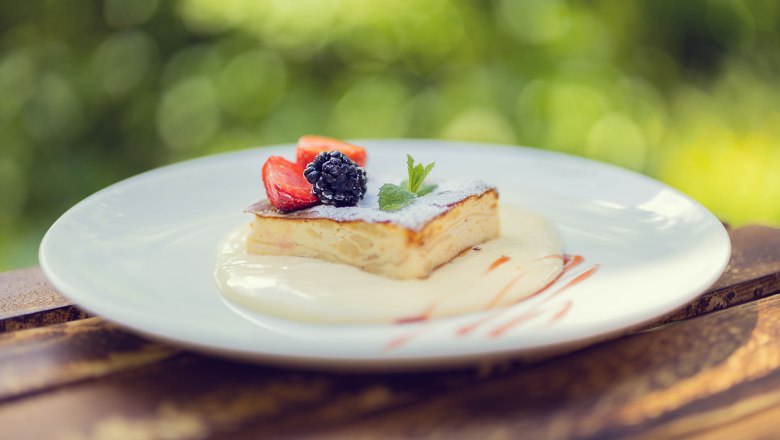 A dessert with berries on a plate outside.