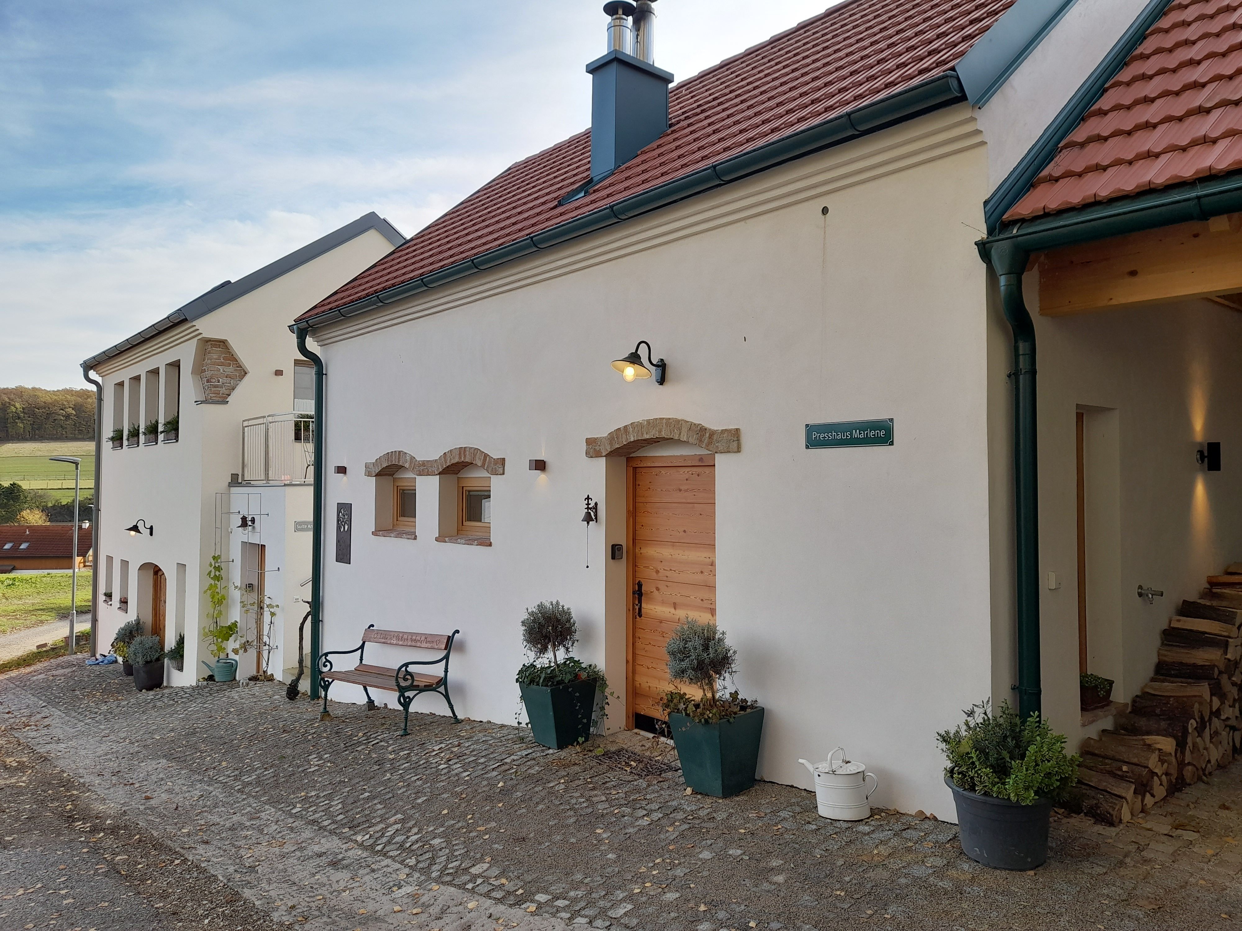 A renovated building with red tiled roofs and a white façade on an organic farm.