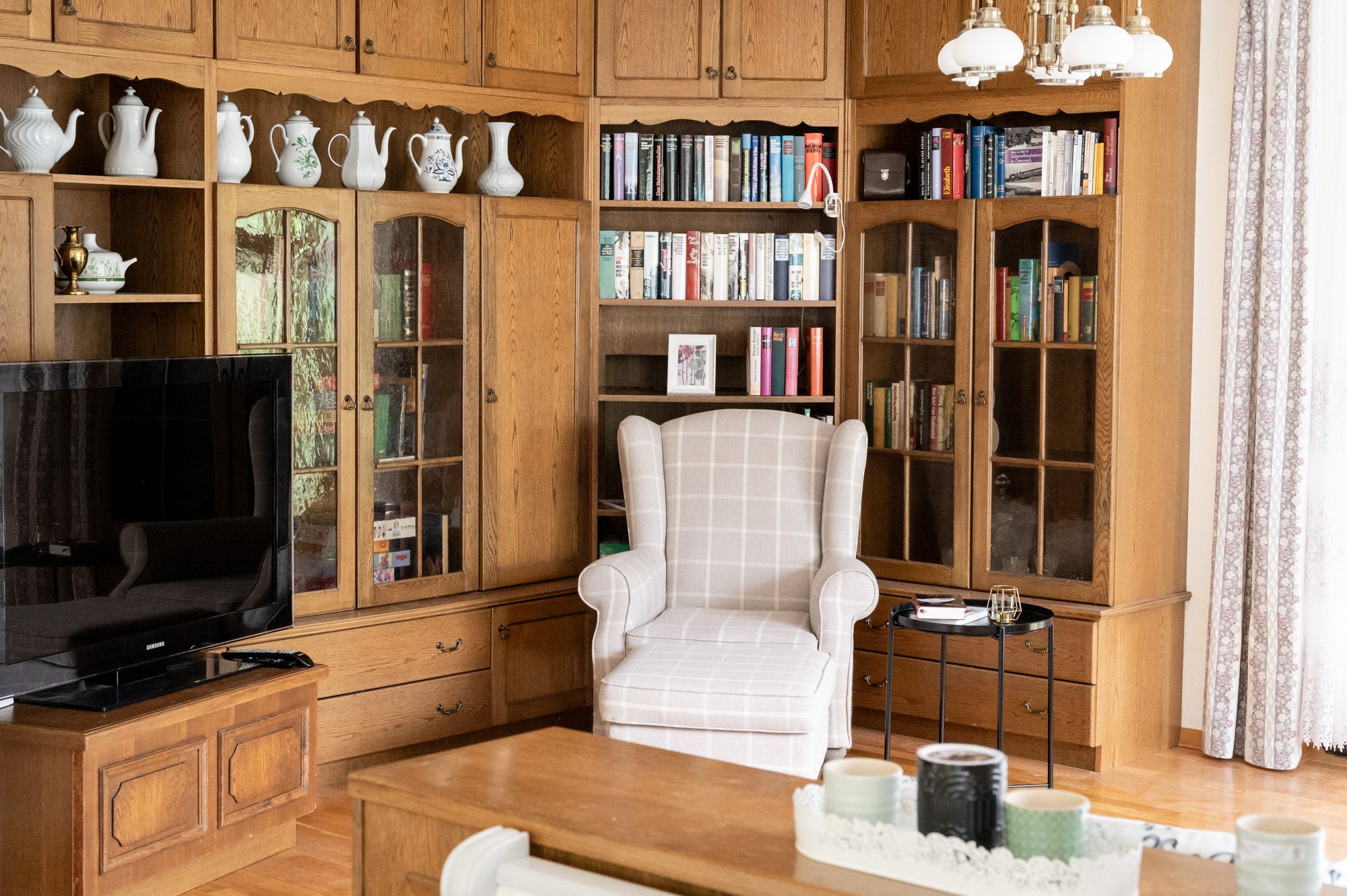 Living room with bookshelf, armchair and TV.