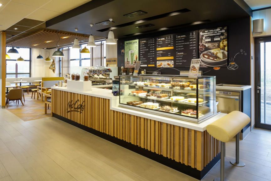 Interior view of a McCafé with counter and seating area.