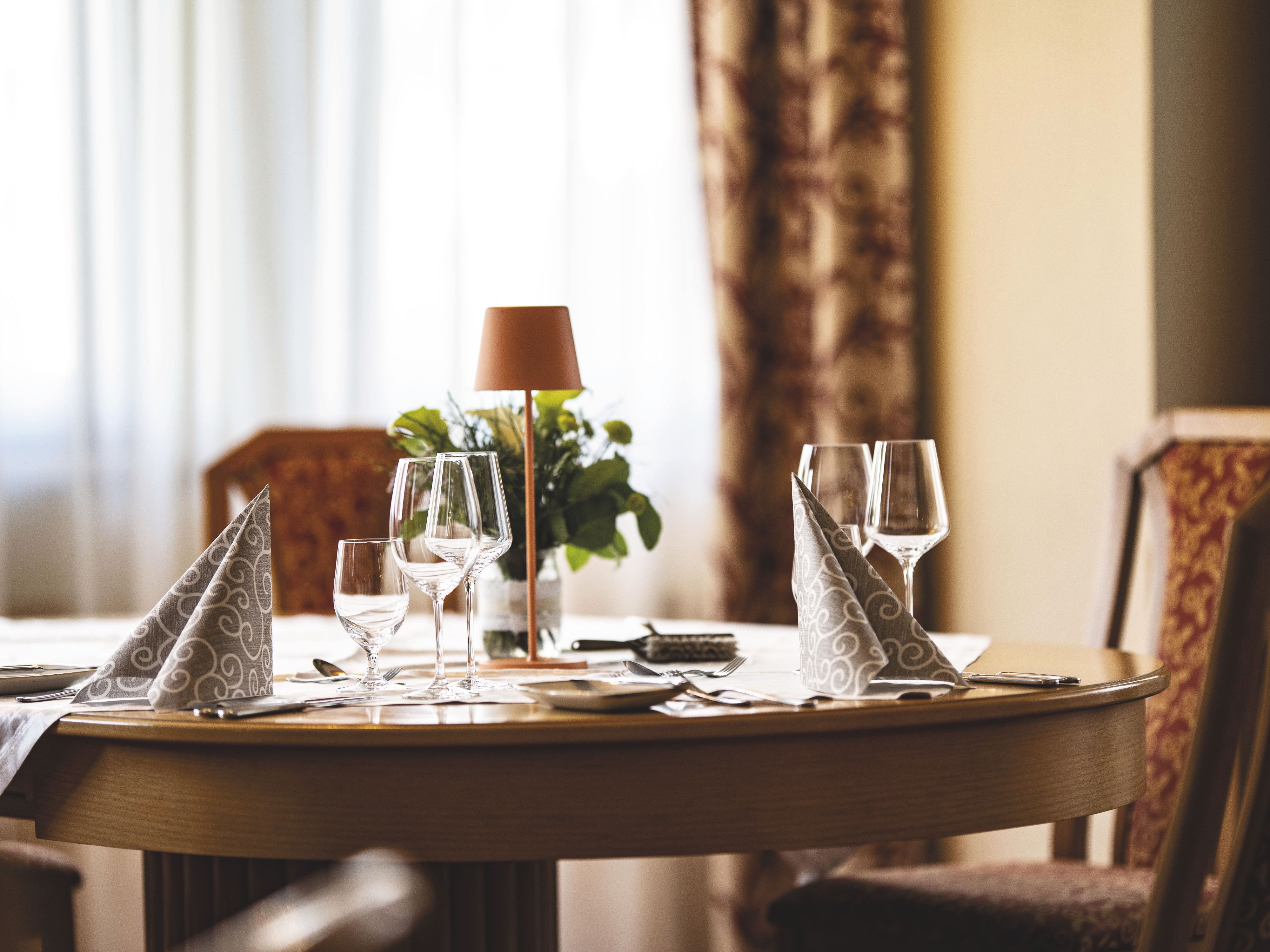 An elegantly set table with wine glasses and napkins in a restaurant.