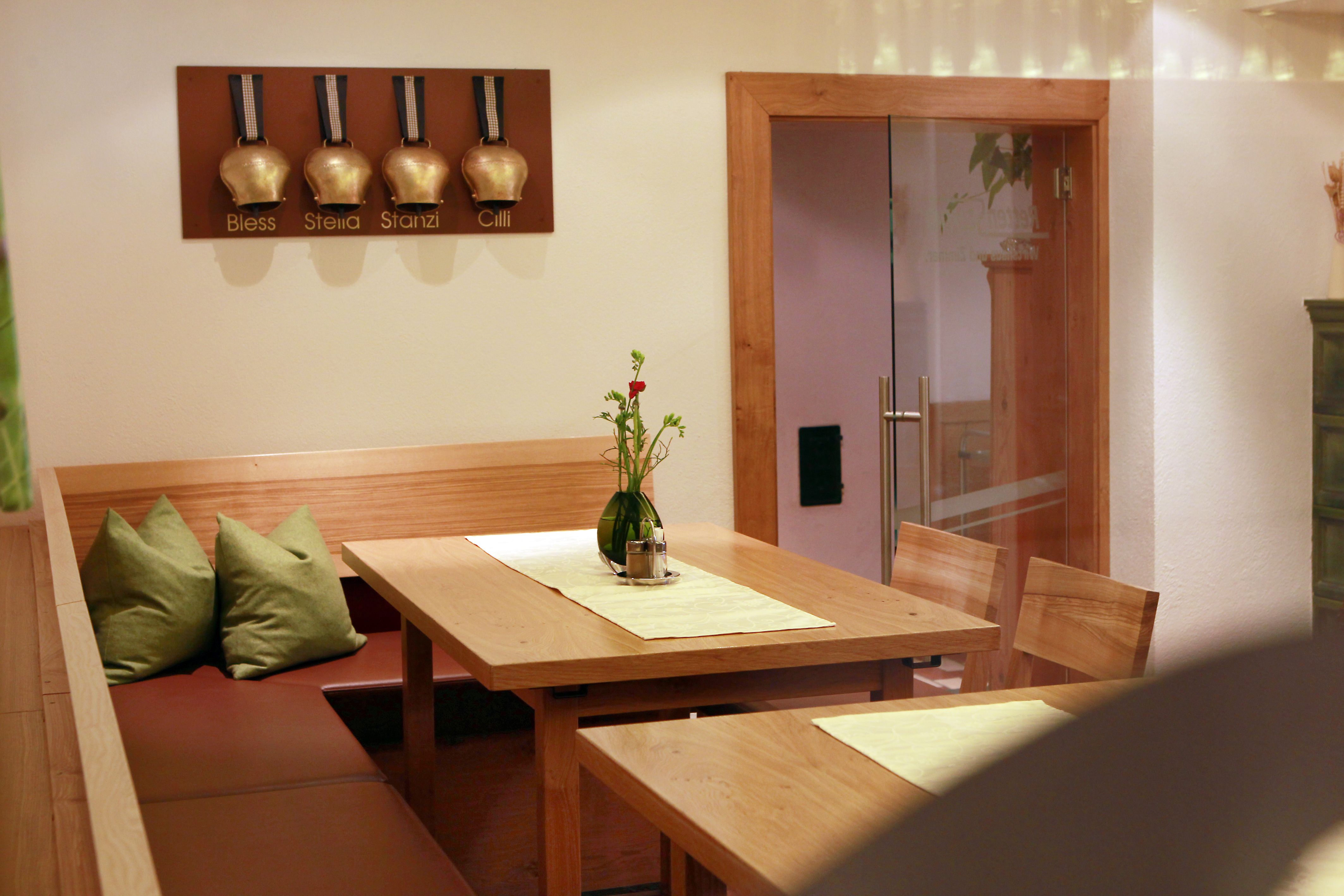 Cozy seating area in a restaurant with wooden table and green cushions.