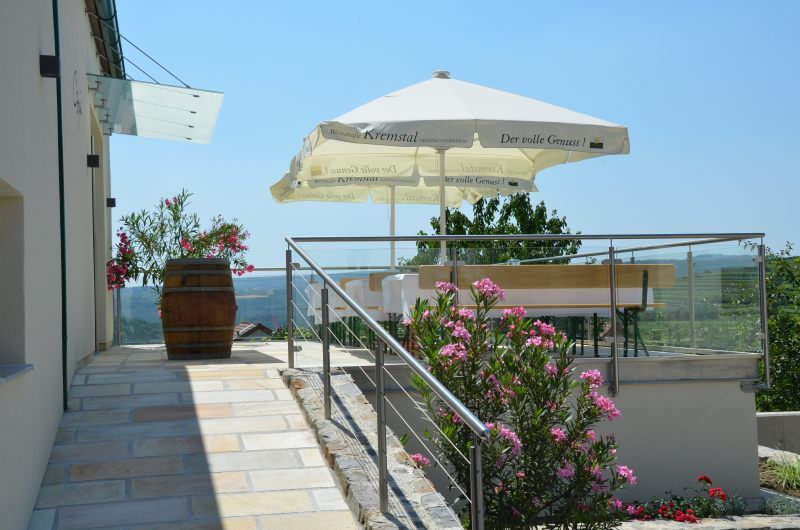 Terrace with parasol and flowers, view of the countryside.