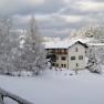Winter landscape with snow-covered inn and trees.