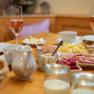 Breakfast table with bread rolls, cold cuts, cheese, champagne glasses and yogurt.
