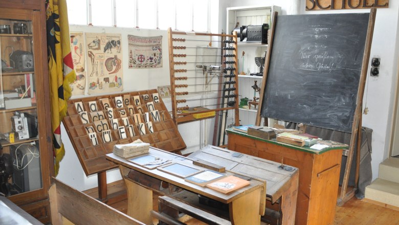 Historical classroom in the Michelhausen local history museum with blackboard, desk and teaching materials.