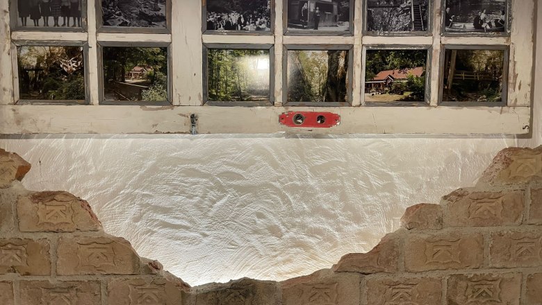 Old windows with historical photos and brick wall.