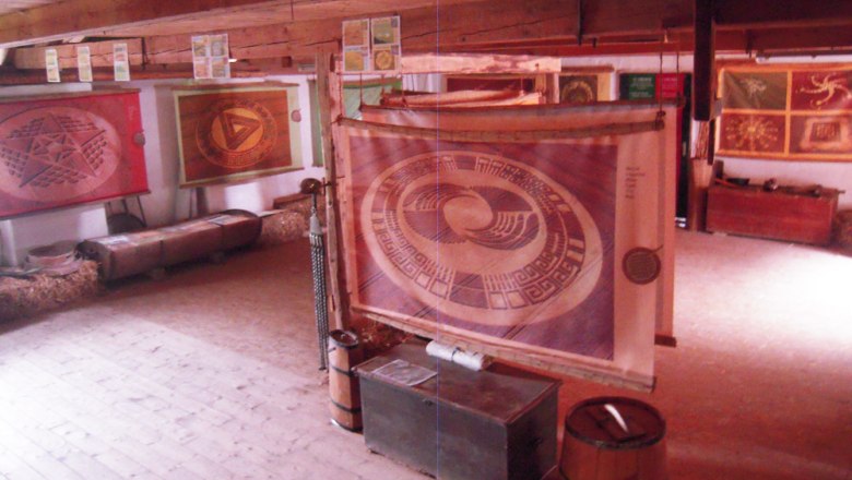 Interior view of a museum with crop circle posters on the walls.