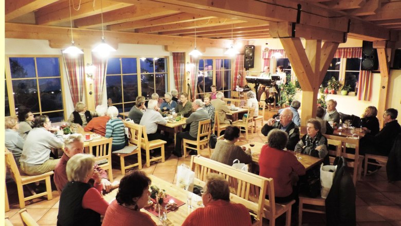 People sit in a cozy dining room with wooden furniture and chat.