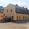 Yellow building of the Gasthof Gansterer in Zöbern with flower boxes and traffic sign.