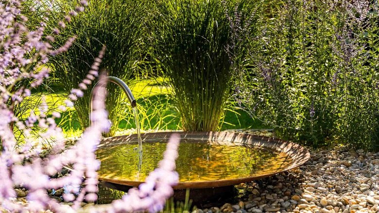 Garden with small fountain and lavender in the foreground.