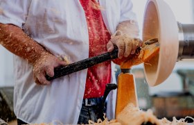 Person turning wood on a lathe.