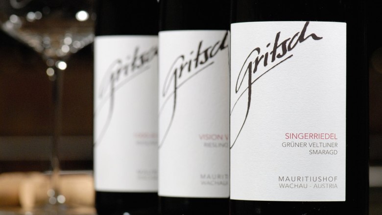 Close-up of three FJ Gritsch wine bottles with labels.