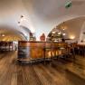 Interior view of a rustic dining room with wooden floor and vaulted ceiling.