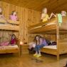 Children play in a room with wooden bunk beds.