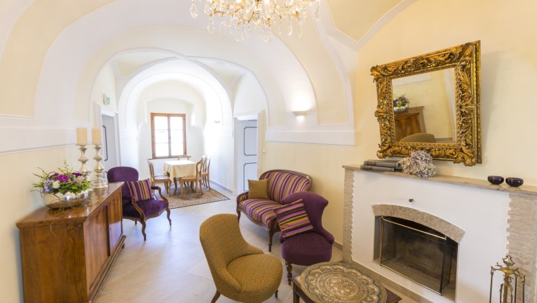 Elegant room with fireplace, antique furniture and chandelier.