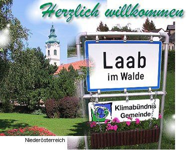 Welcome sign of Laab im Walde with church in the background.