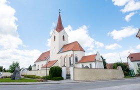 Church in Schweiggers with red roof and tower against a blue sky.