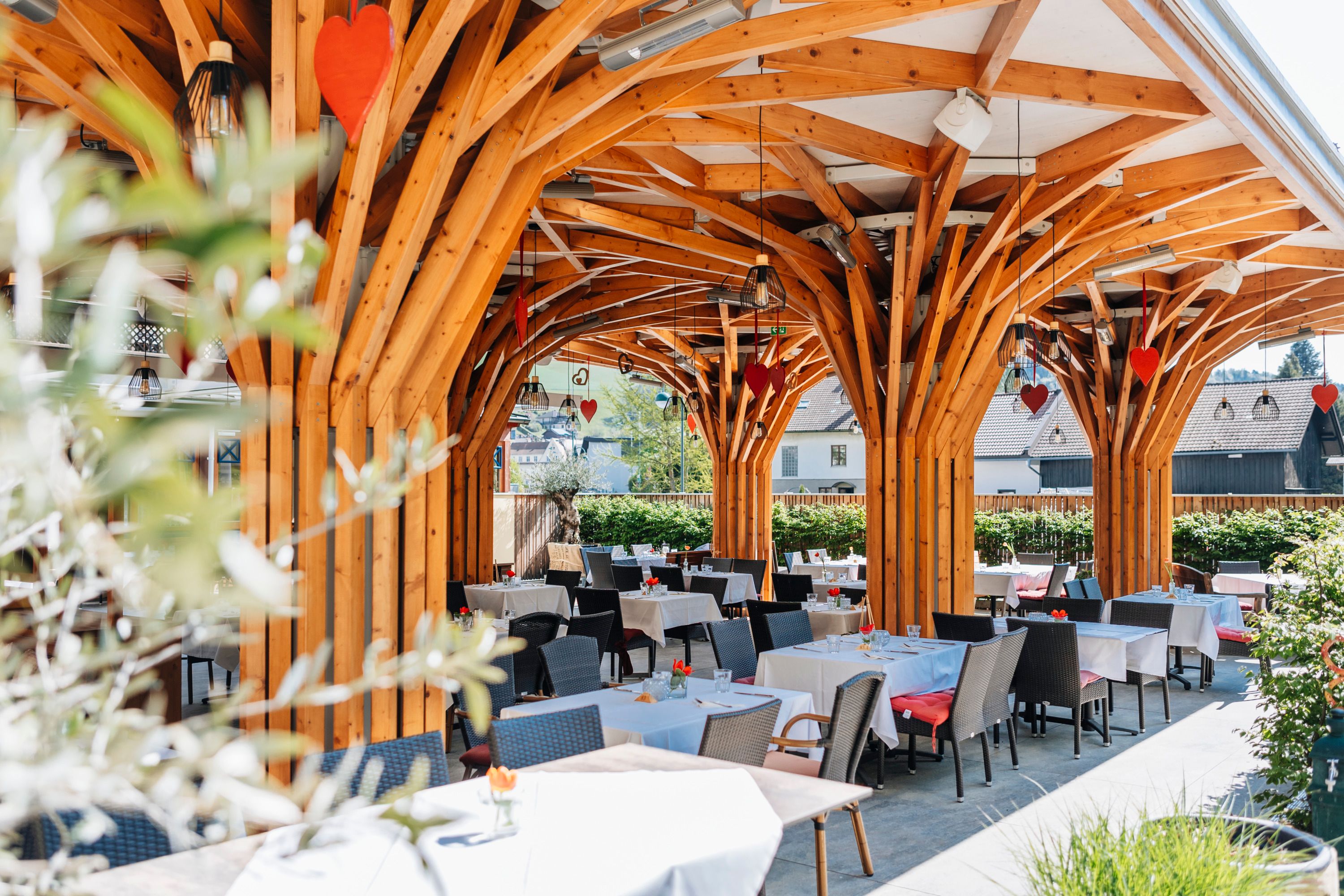 Modern guest garden with wooden construction and covered tables.