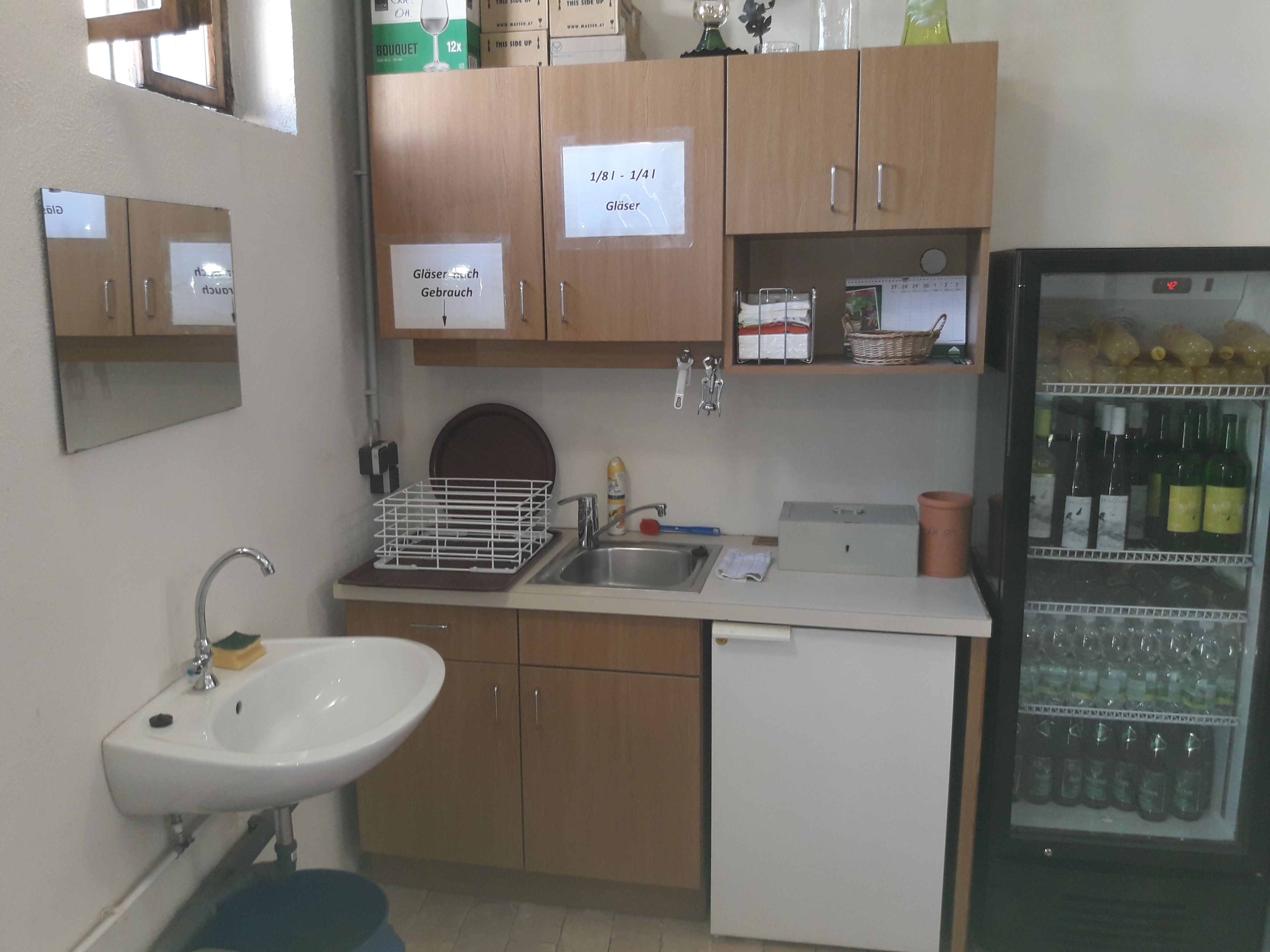 Small kitchenette with a sink, refrigerator, and beverage cooler.