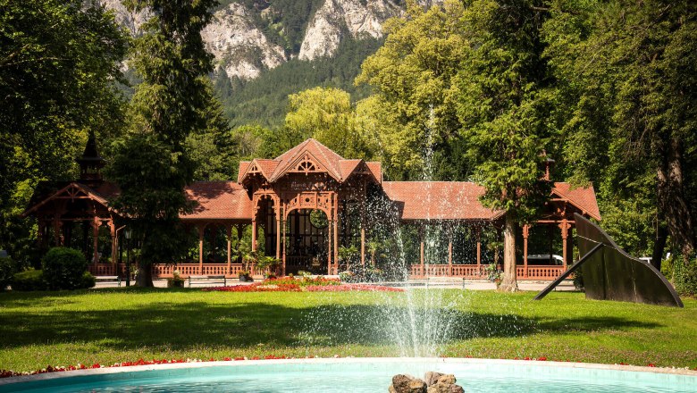 Surrounded by majestic mountains and lush greenery, the historic pavilion exudes an inviting atmosphere. The gentle sounds of water gushing from the fountain harmonize perfectly with the picturesque backdrop and invite you to enjoy the beauty of nature.