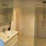 Modern bathroom with shower, washbasin and mirror.