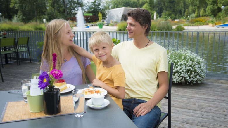 Familie sitzt auf der Terrasse des Restaurants