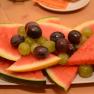 A plate with pieces of watermelon and grapes.