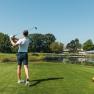 Golfer with golf club in hand, playing golf.