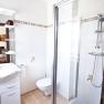 Modern bathroom with shower, washbasin and toilet.